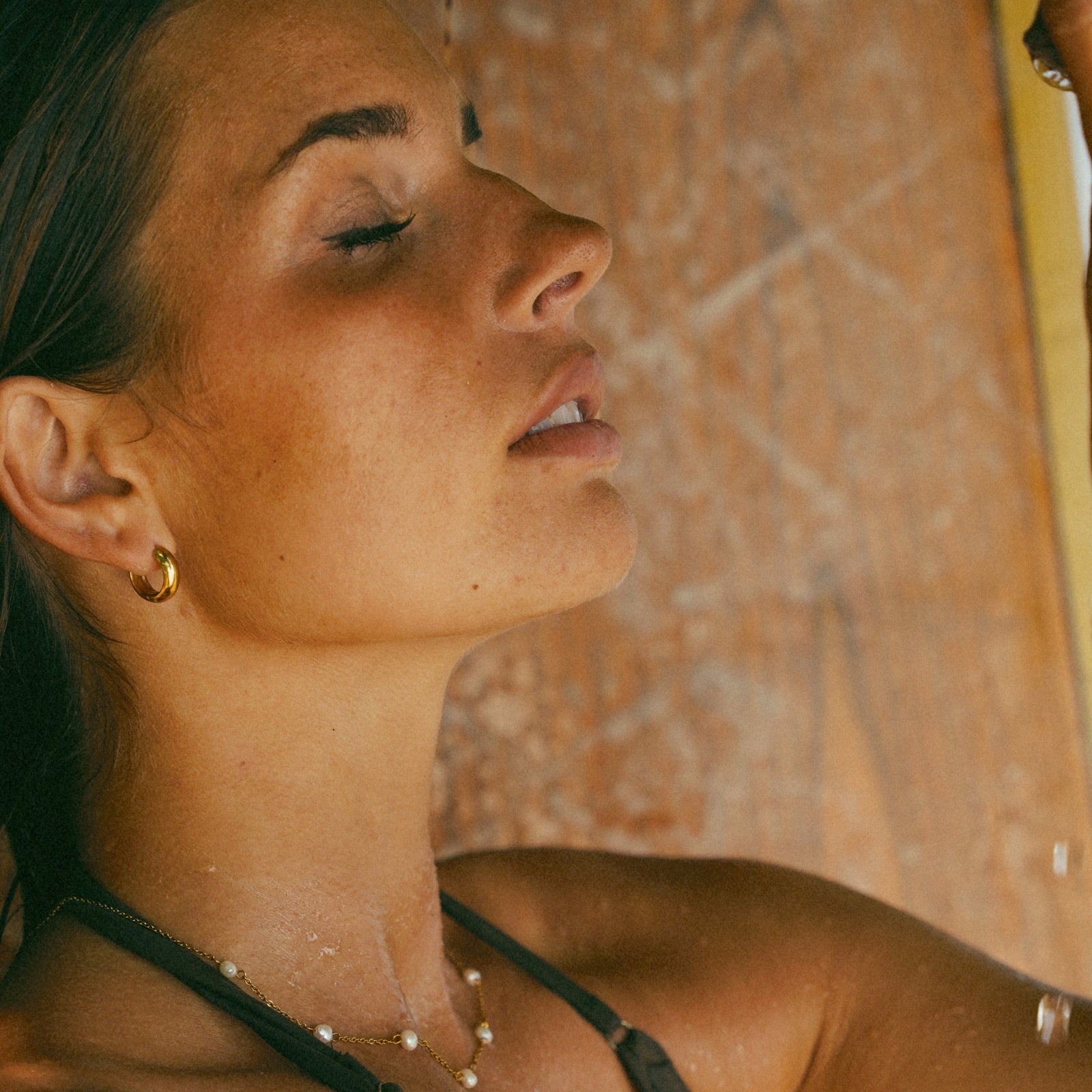 Louise Carter model wearing gold comfort huggie earrings
